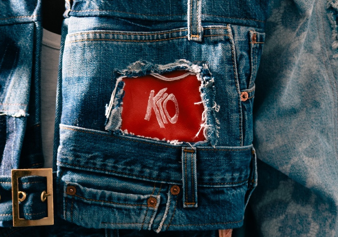 Détail patch cuir KLO sur poche denim